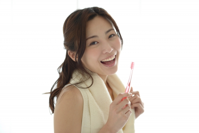 歯ブラシを持つ笑顔の女性